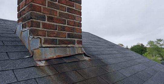 Rust-weeping flashing giving itself away at a chimney base